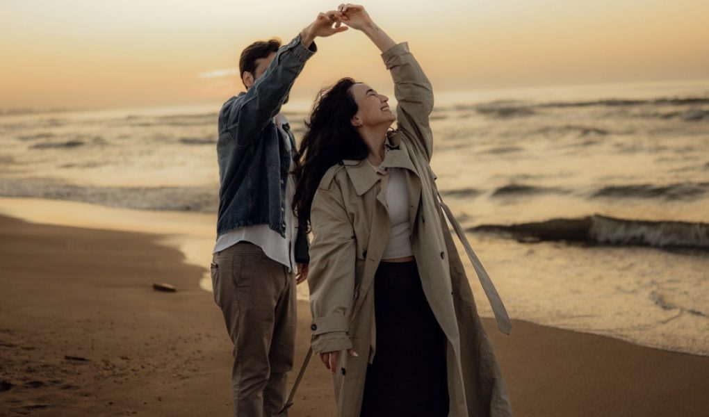 Couple dances together romantically on the beach.
