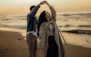 Couple dances together romantically on the beach.